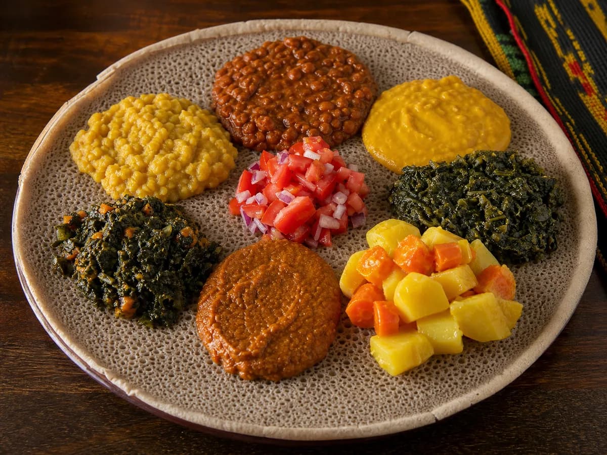 A colorful Ethiopian beyaynetu meal arranged on injera